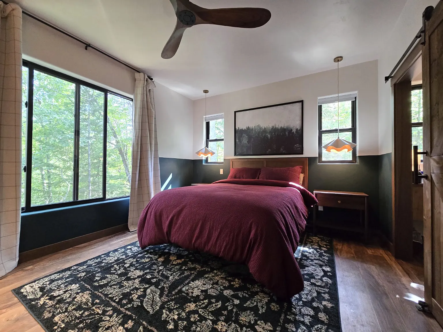 The primary bedroom surrounded by woodland views